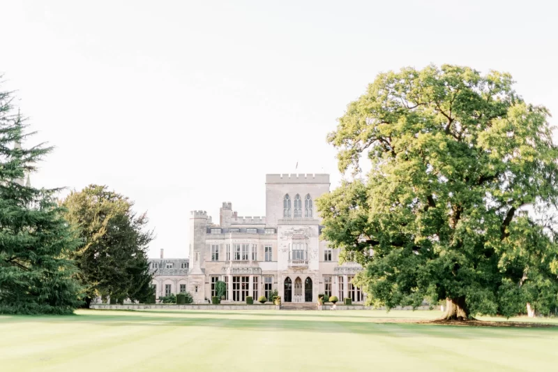 Bride and groom holding hands in front of Ashridge House